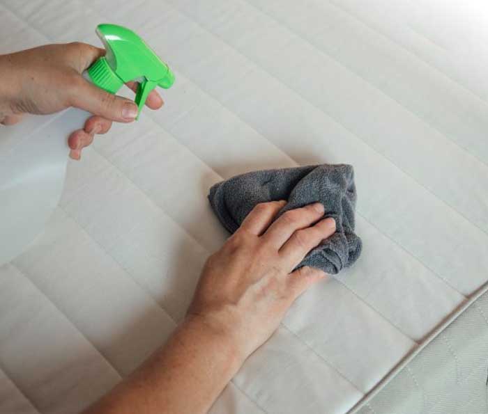 Bạn vệ sinh giường nệm, phủi bụi và lau sạch xung quanh các mép giường, thành nệm